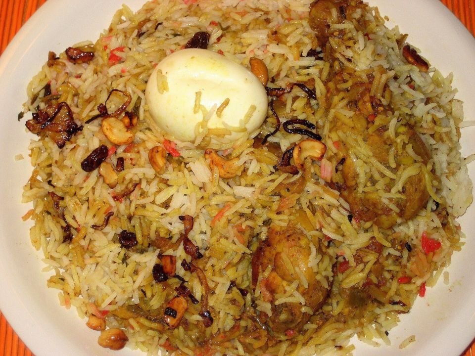 MALABAR CHICKEN BIRYANI<br /><br />Malabar Chicken Biriyani is a non vegetarian rice variety. This delicacy from the Malabar region of Kerala is very popular among Biriyani lovers.<br /><br />Ingredients<br />Basmathi rice - 1 kg<br />Chicken - 1<br />Biriyani Masala Paste<br />(green chilly, cinnamon, cloves, fennel, cardamom, peppercorn) - 4tbsp<br />Green chilly - 10<br />Ginger garlic paste - 2 tbsp<br />Coriander leaves - 50 g<br />Mint leaves - 25 g<br />Curd - 150 ml<br />Tomato - 150 g<br />Onion - 1 kg<br />Black cumin seeds - 1 tsp<br />Cinnamon stick - 2 pieces<br />Bay leaves - 2<br />Cashew nuts kismis - 50 g<br />Cardamom - 5<br />Ghee - 200 g<br />Coriander powder - 2 tbsp<br />Milk - 500 ml<br />Saffron - 1 pinch<br />Water (For rice) - 1 litre<br /><br />Method of preparation<br />Heat the ghee in a saucepan; saute the onions till golden brown colour and add sliced tomatoes saute well. Put ginger garlic paste, curd and biriyani masala and turmeric powder, and coriander powder. Add the chicken pieces and cook well. Soak the rice about 10 minutes and drain well. Melt the ghee in a saucepan and add in the spices and sliced onion mint, coriander leaves, cashew nuts, kismis, bay leaves and saute till brown in colour. Add milk and water. Allow to boil and then add rice. Lower the heat, cover and continue to cook for 15 minutes. Take another saucepan and place half the rice into it. And add the chicken on the top of the rice. And put the remaining rice on top of the chicken. And spread to make an even layer. Make random holes through the rice with a spoon and pour into each a little saffron milk. Place a few knobs of ghee, fried onion, cashew nuts and kismis on the surface and cover tightly.